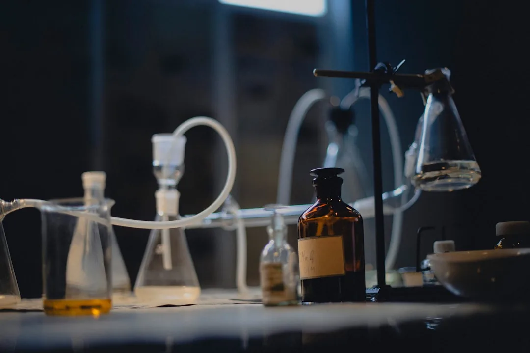 Laboratory glassware on a dark illuminated synthesis bench